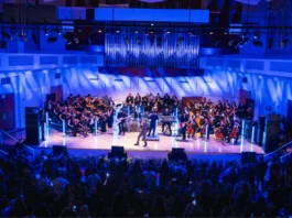 Yandel en el escenario junto a la Orquesta Sinfónica de FIU durante el anuncio de la Beca Yandel Elyte en Miami.
