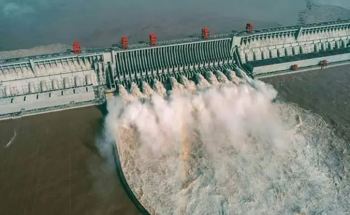 Imagen aérea de la presa de las Tres Gargantas en China, resaltando su imponente estructura y su interacción con el entorno natural.