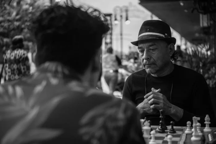 Adultos mayores jugando ajedrez en plaza de Bogotá, tradición que conecta migrantes y locales